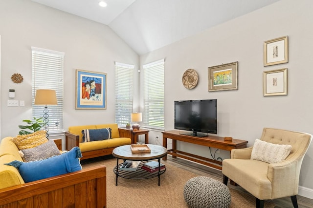 living area featuring baseboards and vaulted ceiling