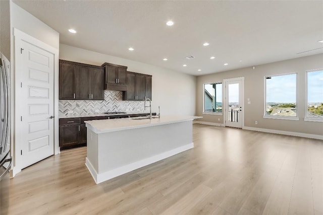 508 Saturnia Cv, Georgetown, TX 78628 - kitchen with a sink, tasteful backsplash, dark brown cabinetry, light wood-style flooring, and gas cooktop