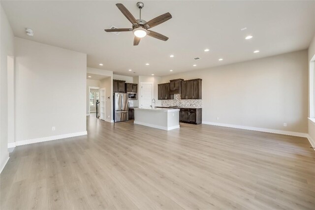 508 Saturnia Cv, Georgetown, TX 78628 - unfurnished living room featuring ceiling fan, a sink, light wood-style floors, recessed lighting, and baseboards