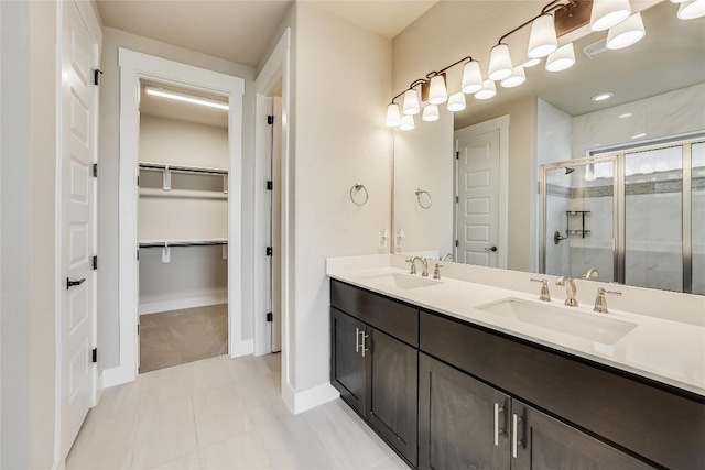 508 Saturnia Cv, Georgetown, TX 78628 - full bathroom with a shower stall, a spacious closet, double vanity, baseboards, and tile patterned flooring