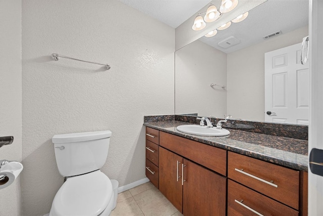 half bathroom featuring vanity, visible vents, toilet, tile patterned floors, and baseboards