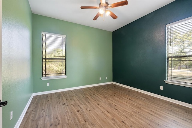unfurnished room featuring baseboards, a ceiling fan, and wood finished floors