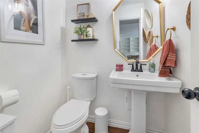 bathroom with toilet and wood finished floors