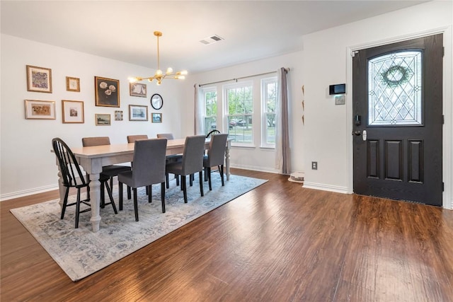 dining area featuring a chandelier, dark wood-style floors, and baseboards