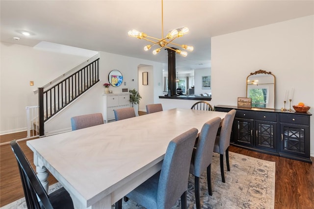 dining area featuring stairs, wood finished floors, a chandelier, and arched walkways