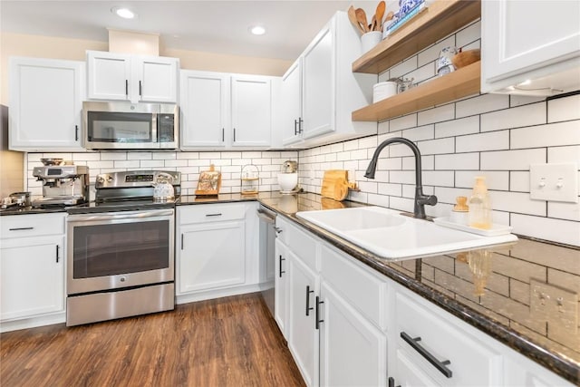 kitchen featuring stainless steel appliances, a sink, open shelves, white cabinets, and recessed lighting