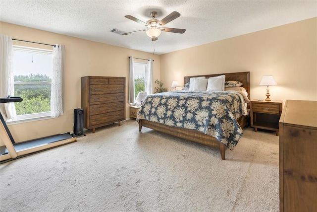 bedroom featuring carpet, a textured ceiling, radiator heating unit, and ceiling fan