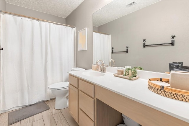 bathroom featuring toilet, a textured ceiling, vanity, and a shower with shower curtain