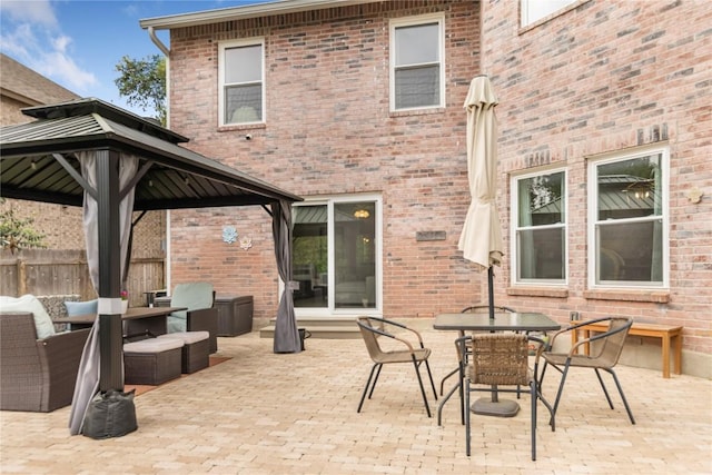 view of patio with a gazebo, fence, outdoor dining space, and outdoor lounge area