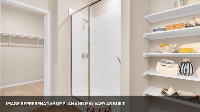 395 Morning Glory Loop, Kyle, TX 78640 - bathroom featuring a shower stall, a spacious closet, and baseboards