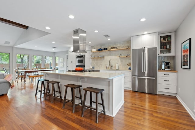 5911 W Gate Blvd, Austin, TX 78745 - kitchen featuring stainless steel appliances, decorative backsplash, light countertops, open shelves, and a center island
