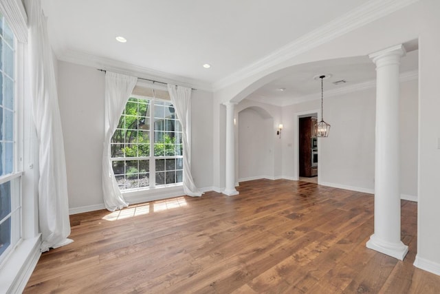 interior space with crown molding, arched walkways, recessed lighting, wood finished floors, and baseboards