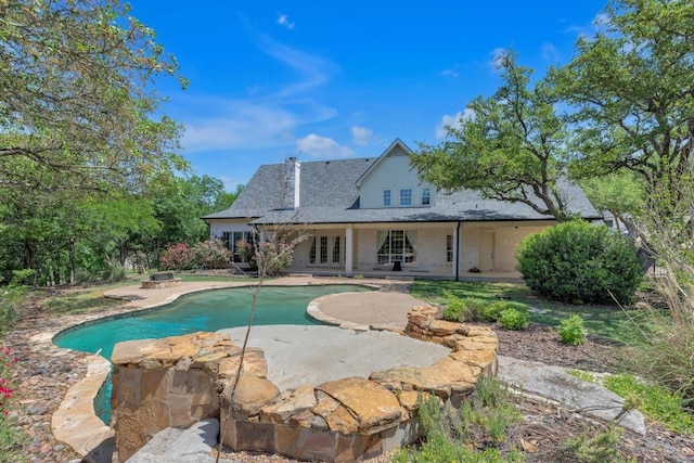 view of swimming pool featuring french doors and a patio