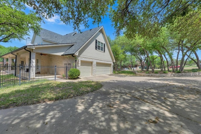 view of property exterior with ceiling fan, a garage, fence, concrete driveway, and roof with shingles