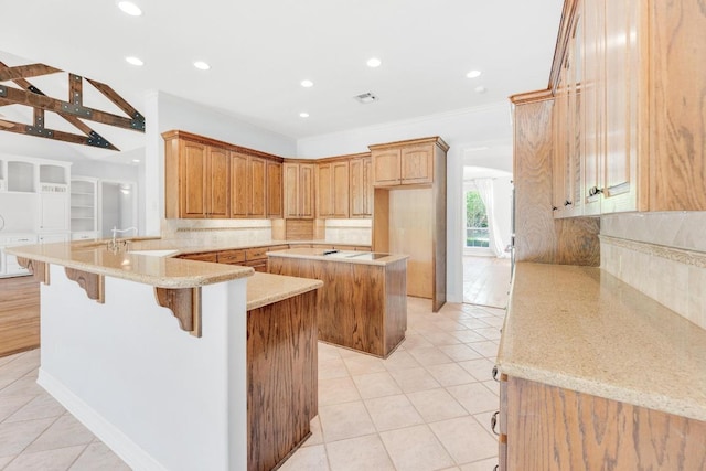 kitchen with a sink, light tile patterned floors, decorative backsplash, and a peninsula
