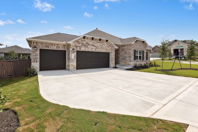220 Washington Dr, Kyle, TX 78640 - view of front of home featuring an attached garage, driveway, a shingled roof, brick siding, and stone siding