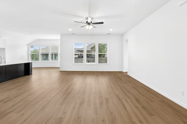 220 Washington Dr, Kyle, TX 78640 - unfurnished living room with ceiling fan, baseboards, light wood-style floors, and recessed lighting