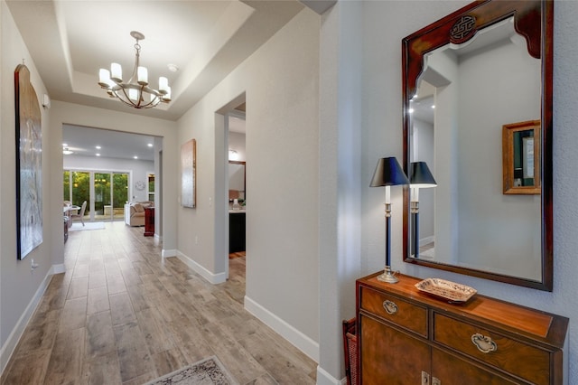 262 Singing Sumac Way, San Marcos, TX 78666 - hall with a chandelier, light wood-style floors, and a tray ceiling