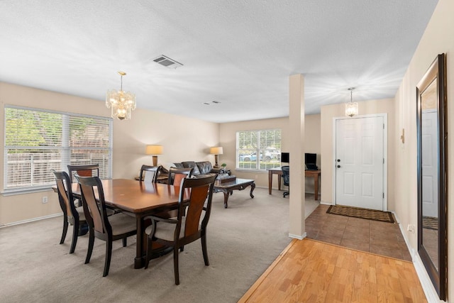 141 Sydneys Way, Buda, TX 78610 - dining space featuring a chandelier, light wood-type flooring, and light colored carpet