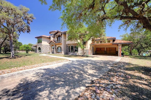 mediterranean / spanish-style home featuring a tile roof, aphalt driveway, stone siding, and stucco siding