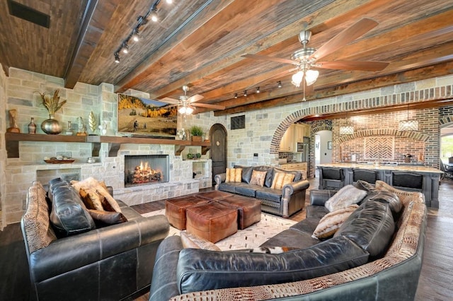 200 Skippin Stone Ln, Concan, TX 78801 - living area featuring track lighting, a ceiling fan, a wooden ceiling with exposed beams, arched walkways, and wood finished floors