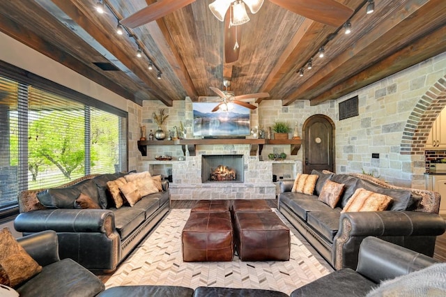 living room featuring ceiling fan, rail lighting, arched walkways, and wood ceiling
