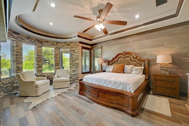 bedroom featuring a raised ceiling, wood finished floors, visible vents, and recessed lighting