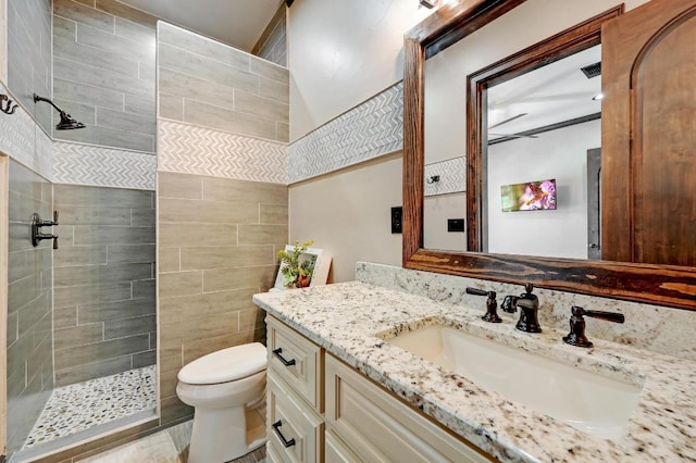 bathroom with a walk in shower, vanity, visible vents, and toilet