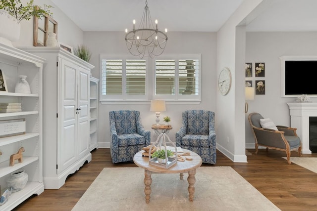 121 Monterey Oak Trl, Georgetown, TX 78628 - living area featuring dark wood-style floors, an inviting chandelier, a glass covered fireplace, and baseboards
