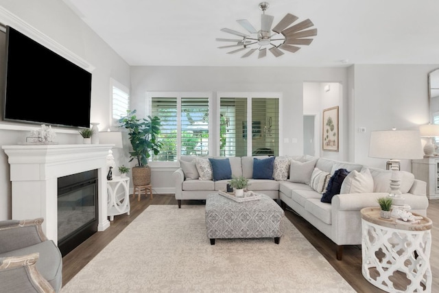 121 Monterey Oak Trl, Georgetown, TX 78628 - living room featuring baseboards, wood finished floors, a ceiling fan, and a glass covered fireplace