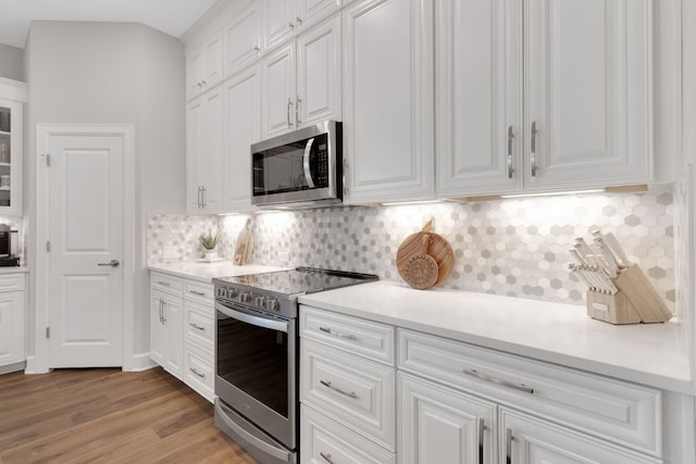 121 Monterey Oak Trl, Georgetown, TX 78628 - kitchen with white cabinets, stainless steel appliances, backsplash, and light countertops