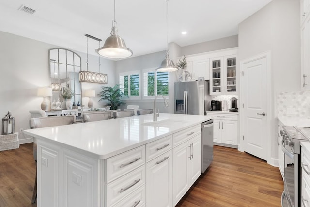 121 Monterey Oak Trl, Georgetown, TX 78628 - kitchen with glass insert cabinets, decorative backsplash, appliances with stainless steel finishes, a sink, and visible vents