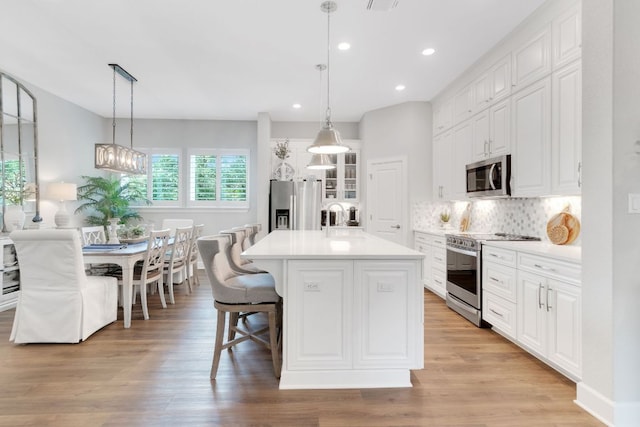121 Monterey Oak Trl, Georgetown, TX 78628 - kitchen featuring white cabinets, tasteful backsplash, stainless steel appliances, and light countertops