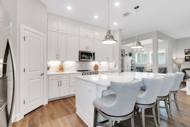 121 Monterey Oak Trl, Georgetown, TX 78628 - kitchen featuring a breakfast bar, visible vents, stainless steel appliances, and a sink