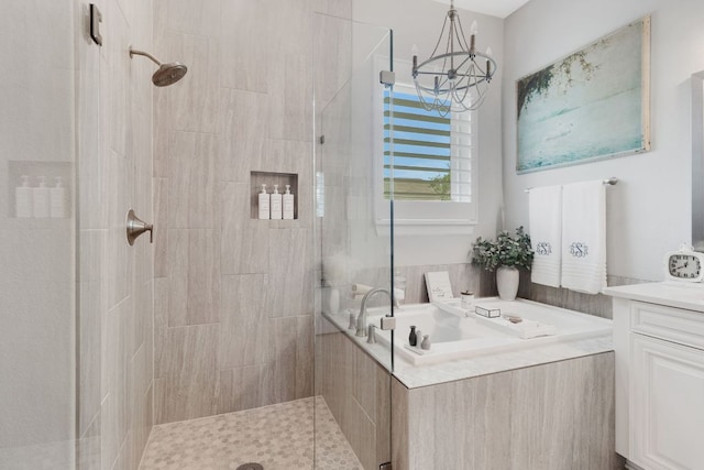 121 Monterey Oak Trl, Georgetown, TX 78628 - bathroom featuring a stall shower, a notable chandelier, a bath, and vanity