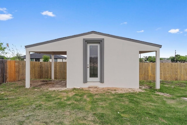 view of home's exterior featuring stucco siding, fence, and a lawn