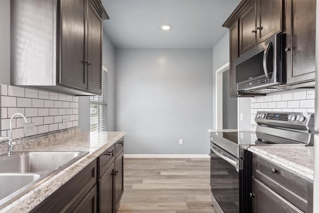 kitchen featuring a sink, light countertops, dark brown cabinets, stainless steel appliances, and decorative backsplash