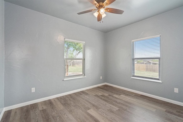 empty room with wood finished floors, ceiling fan, and baseboards