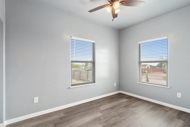 empty room with wood finished floors, baseboards, and a ceiling fan