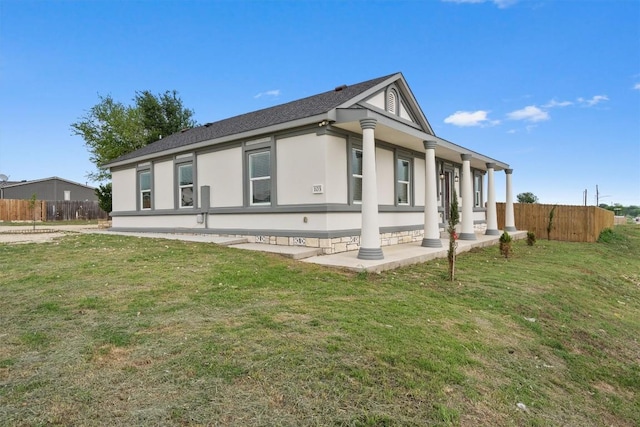view of property exterior featuring a yard, stucco siding, and fence