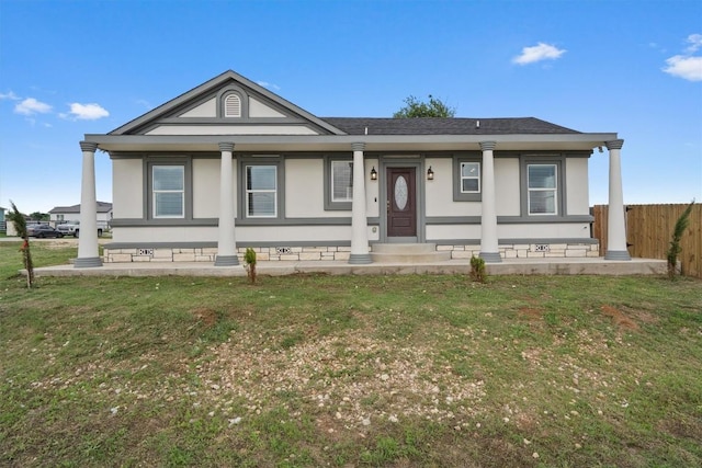 view of front of house featuring a shingled roof, stucco siding, fence, and a front lawn