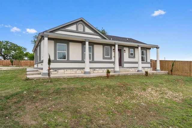 view of front facade featuring stucco siding, fence, and a front lawn