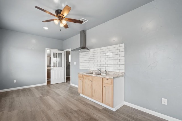 kitchen featuring ceiling fan, light brown cabinetry, ventilation hood, visible vents, and a sink