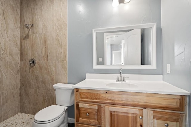 full bath with toilet, tiled shower, and vanity