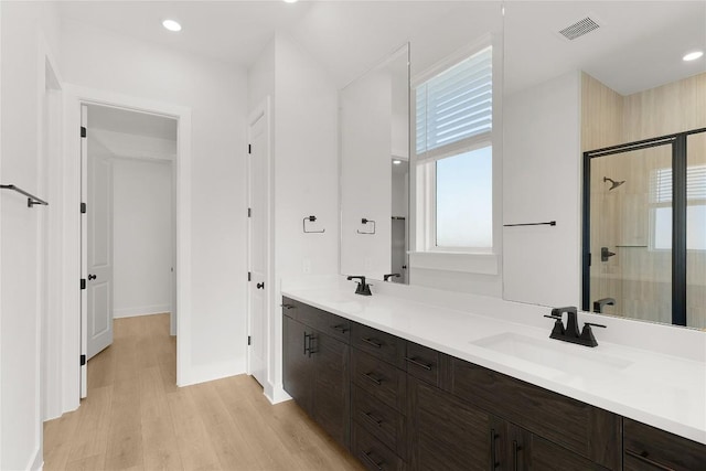 508 Raleigh Dr, Georgetown, TX 78633 - bathroom with healthy amount of natural light, tiled shower, wood finished floors, double vanity, and recessed lighting
