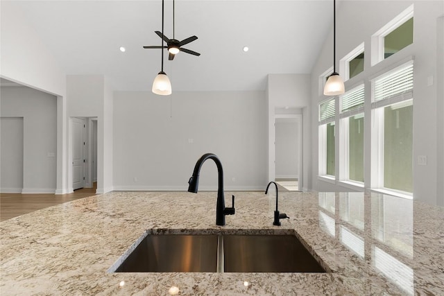 508 Raleigh Dr, Georgetown, TX 78633 - kitchen with a ceiling fan, hanging light fixtures, light stone counters, and high vaulted ceiling