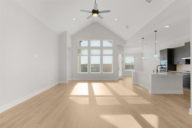 508 Raleigh Dr, Georgetown, TX 78633 - unfurnished living room with a ceiling fan, light wood-style flooring, high vaulted ceiling, and recessed lighting