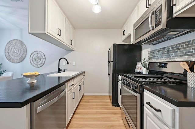 3309 Clawson Rd, Austin, TX 78704 - kitchen featuring appliances with stainless steel finishes, a sink, dark countertops, and decorative backsplash