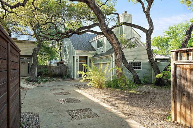 view of home's exterior featuring fence and a chimney