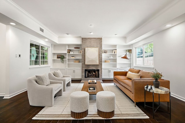 living area with hardwood / wood-style flooring, visible vents, baseboards, and crown molding